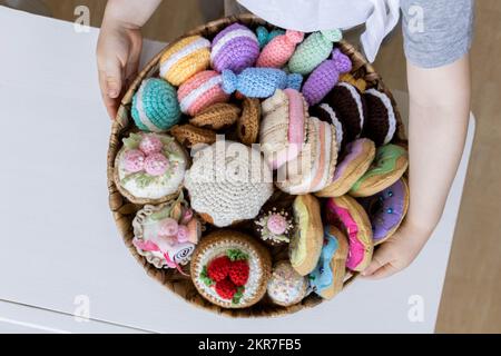 Cibo giocattolo lavorato a maglia da filato. Dolci, dolci, biscotti e torte. Foto Stock