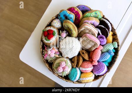 Cibo giocattolo lavorato a maglia da filato. Dolci, dolci, biscotti e torte. Foto Stock