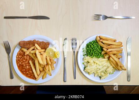 Cene scolastiche - fish & chips con piselli e formaggio e broccoli con patatine. Foto Stock