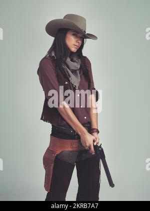 Ho avuto il mio occhio su di te... una giovane donna attraente in abbigliamento da cowboy. Foto Stock