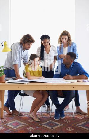 Il lavoro di squadra fa il lavoro di sogno. Un gruppo di giovani colleghi che discutono del lavoro. Foto Stock