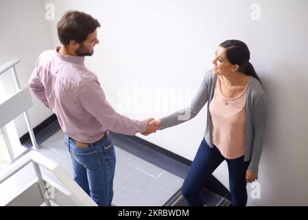 Youll andare lontano. due giovani che scuotono le mani in una scala. Foto Stock