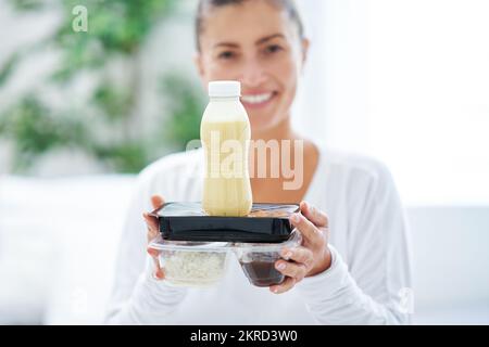 Giovane donna a letto con scatola cibo catering Foto Stock