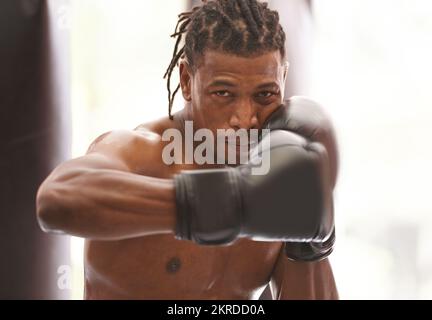 Pronto per tutto youll buttare a lui. Ritratto di un giovane pugile che pratica in palestra. Foto Stock