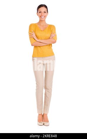 Shes soddisfatto della vita. Una giovane donna vestita casualmente in piedi con le braccia piegate. Foto Stock