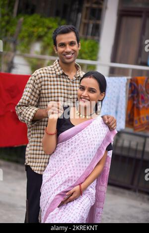 Ritratto di felice giovane coppia in piedi insieme nel cortile Foto Stock