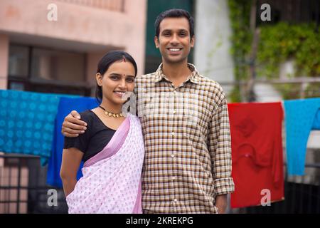 Ritratto di felice giovane coppia in piedi insieme nel cortile Foto Stock
