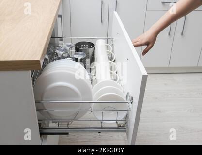 Ripiano estraibile con piatti in una cucina modulare. Mobili da cucina moderni. Produzione di cucine sotto l'ordine, lavori di casa Foto Stock