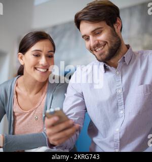 Amo le memorie di tesi. due giovani impiegati che guardano insieme un messaggio di testo. Foto Stock