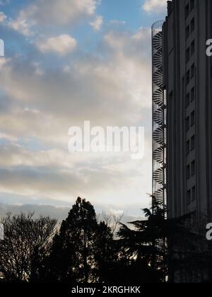 Il fuoco a spirale sfugge a un edificio alto. Alto edificio di appartamenti con fughe di emergenza. Foto Stock