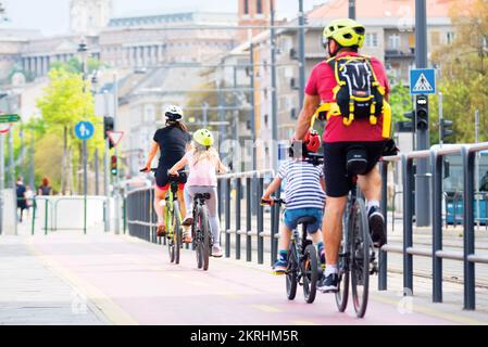 Famiglia in bicicletta in città Foto Stock