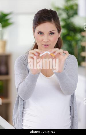 donna incinta che rompe un concetto di fumo di arresto della sigaretta Foto Stock