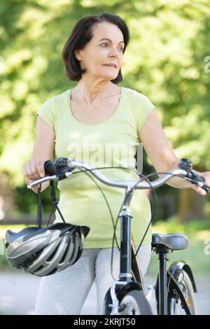 donna anziana che ama andare in bicicletta Foto Stock