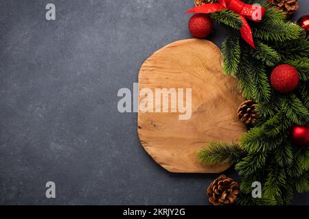 Set tavola di Natale composto da un tagliere e posate legate con un arco. Vista dall'alto con spazio di copia Foto Stock