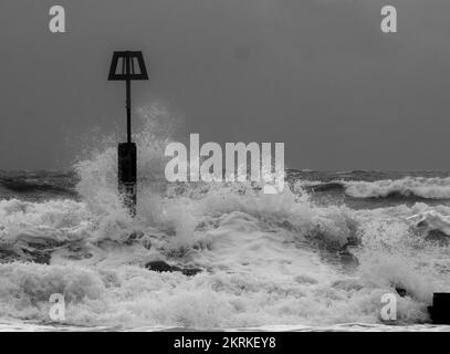 Onde invernali schizzare contro i marcatori di Groyne sulla spiaggia di Boscombe, Bournemouth Foto Stock