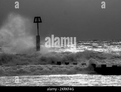 Onde invernali schizzare contro i marcatori di Groyne sulla spiaggia di Boscombe, Bournemouth Foto Stock