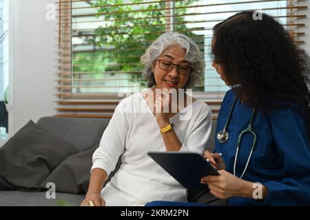 Medico attento che istruisce circa il trattamento, dando la consultazione professionale alla donna anziana. Concetto di servizio sanitario domestico Foto Stock