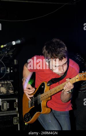 SAMUEL PRESTON, THE ORDINARY BOYS, 2004: Un giovane Samuel Preston in rosso, cantante e chitarrista dei The Ordinary Boys al Welsh Club di Cardiff, Galles, Regno Unito, il 19 ottobre 2004. Fotografia: ROB WATKINS. INFO: The Ordinary Boys sono un gruppo musicale indie rock britannico formatosi nel 2002 a Worthing. Noti per il loro suono energico e i testi socialmente consapevoli, hanno guadagnato fama con il loro album di debutto "Over the Counter Culture" e successi come "Boys Will Be Boys". Foto Stock