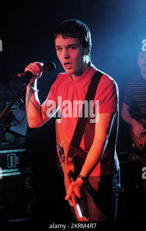 SAMUEL PRESTON, THE ORDINARY BOYS, 2004: Un giovane Samuel Preston in rosso, cantante e chitarrista dei The Ordinary Boys al Welsh Club di Cardiff, Galles, Regno Unito, il 19 ottobre 2004. Fotografia: ROB WATKINS. INFO: The Ordinary Boys sono un gruppo musicale indie rock britannico formatosi nel 2002 a Worthing. Noti per il loro suono energico e i testi socialmente consapevoli, hanno guadagnato fama con il loro album di debutto "Over the Counter Culture" e successi come "Boys Will Be Boys". Foto Stock