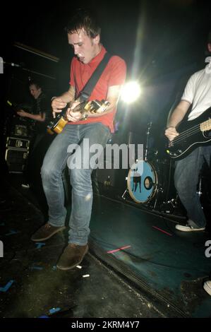 SAMUEL PRESTON, THE ORDINARY BOYS, 2004: Un giovane Samuel Preston in rosso, cantante e chitarrista dei The Ordinary Boys al Welsh Club di Cardiff, Galles, Regno Unito, il 19 ottobre 2004. Fotografia: ROB WATKINS. INFO: The Ordinary Boys sono un gruppo musicale indie rock britannico formatosi nel 2002 a Worthing. Noti per il loro suono energico e i testi socialmente consapevoli, hanno guadagnato fama con il loro album di debutto "Over the Counter Culture" e successi come "Boys Will Be Boys". Foto Stock