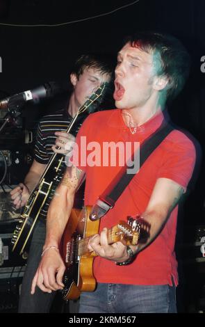 SAMUEL PRESTON, THE ORDINARY BOYS, 2004: Un giovane Samuel Preston in rosso, cantante e chitarrista dei The Ordinary Boys al Welsh Club di Cardiff, Galles, Regno Unito, il 19 ottobre 2004. Fotografia: ROB WATKINS. INFO: The Ordinary Boys sono un gruppo musicale indie rock britannico formatosi nel 2002 a Worthing. Noti per il loro suono energico e i testi socialmente consapevoli, hanno guadagnato fama con il loro album di debutto "Over the Counter Culture" e successi come "Boys Will Be Boys". Foto Stock