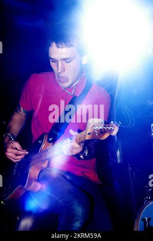 SAMUEL PRESTON, THE ORDINARY BOYS, 2004: Un giovane Samuel Preston in rosso, cantante e chitarrista dei The Ordinary Boys al Welsh Club di Cardiff, Galles, Regno Unito, il 19 ottobre 2004. Fotografia: ROB WATKINS. INFO: The Ordinary Boys sono un gruppo musicale indie rock britannico formatosi nel 2002 a Worthing. Noti per il loro suono energico e i testi socialmente consapevoli, hanno guadagnato fama con il loro album di debutto "Over the Counter Culture" e successi come "Boys Will Be Boys". Foto Stock