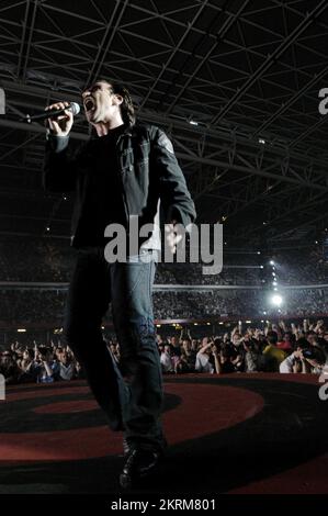 BONO, U2, WORLD TOUR CONCERT, 2005: Cantante Bono della band irlandese U2 al Millennium Stadium di Cardiff, giugno 29 2005. Fotografia: ROB WATKINS. INFO: U2 è un gruppo rock irlandese formatosi nel 1976, rinomato per il loro suono antematico e i testi socialmente consapevoli. Con album iconici come "The Joshua Tree" e "Achtung Baby", hanno raggiunto la fama mondiale, guidati dal carismatico frontman Bono e dall'innovativo chitarrista The Edge. Foto Stock