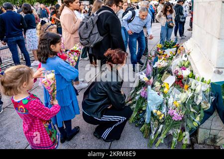 I bambini che posano tributi floreali di fronte ai cancelli di Buckingham Palace dopo la morte della regina Elisabetta II, Londra, Regno Unito. Foto Stock