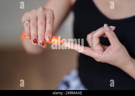 Crop anonymous etnico femmina dimostrando la crema mentre mettendo la sostanza sul dito da tubo in makeup studio Foto Stock