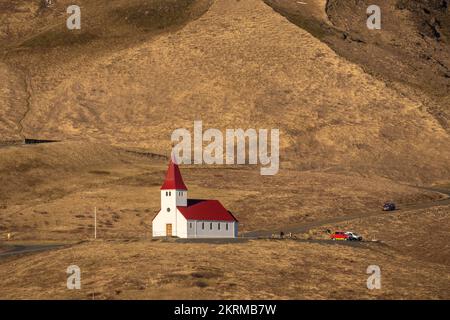 Chiesa di Reyniskyrka situata su una collina erbosa in campagna nella giornata di sole a Vik, Islanda Foto Stock