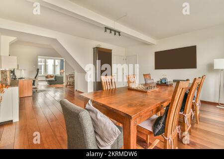 Tavolo in soggiorno e con computer moderno in un ampio ufficio con sedie e pavimento in legno alla luce del sole Foto Stock