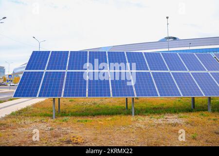 Pannelli solari montati a terra sull'erba in città, energia pulita e energia ambientale dalla luce solare per ridurre il riscaldamento globale in tutto il mondo. Po. Solare Foto Stock