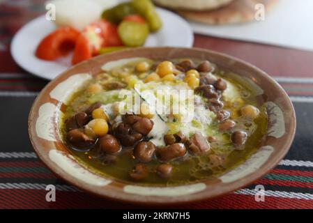 Hummus con Fuul (Ful), un popolare cibo di base nel medio-est. Abu Kamel ristorante nel quartiere cristiano nella città vecchia di Gerusalemme. Foto Stock