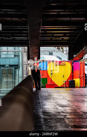 Una giovane coppia in un romantico abbraccio sotto Waterloo Bridge a Londra Foto Stock