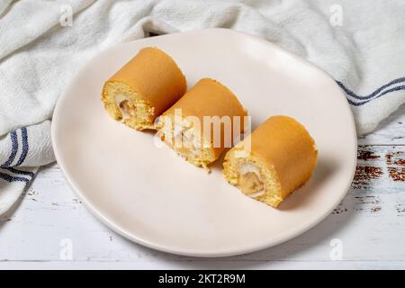 Panino di banana. Snack torta roll su uno sfondo di legno bianco. primo piano Foto Stock