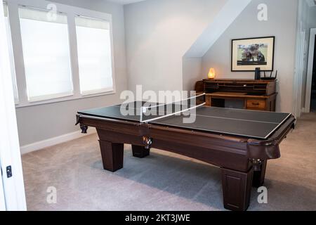 Una sala giochi o sala bonus al piano superiore con un tavolo da biliardo convertito in una partita di ping pong Foto Stock