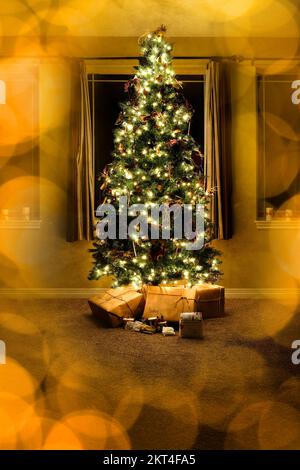 Albero di Natale nel soggiorno della casa con i regali avvolti alle finestre di notte fuori fuoco luci dorate Foto Stock