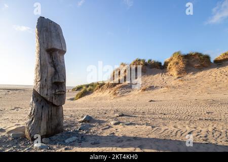 Statua in legno intagliata dell'uomo Maori dell'isola di Pasqua sulla spiaggia di Barmouth Foto Stock