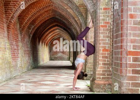 Yoga con mattone. Sottile atletica caucasica donna pratica yoga posa  utilizzando blocco rosa in sala fitness al coperto Foto stock - Alamy