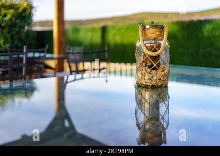 Vaso di vetro con pietre sulla parte superiore di un rustico tavolo casa di campagna. Foto Stock