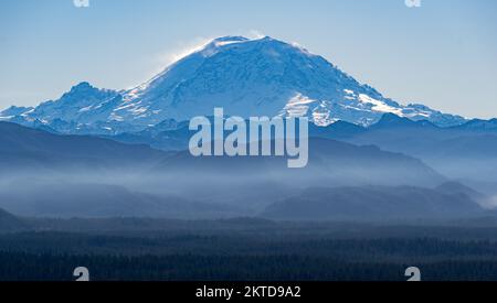 Una vista del Monte Rainier vicino a Seattle con strati di colline avvolte nella nebbia davanti Foto Stock