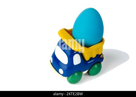 Un camion giocattolo per bambini trasporta un uovo regalo di Pasqua Foto Stock