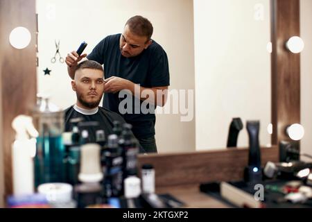 Barbiere uomo caucasico in barbiere Foto Stock
