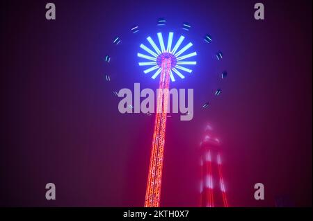 La nebbia e la nebbia marina di fine novembre non hanno rovinato il lightshow alla fiera di Natale di Blackpool del 2022. Blackpool Tower avvolta nella nebbia con il giro in primo piano dello Star Flyer Foto Stock
