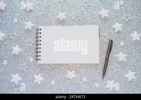 Un notebook con una penna su uno sfondo di Natale. La pianificazione concettuale, facendo un elenco di cose da fare nel nuovo anno. Foto Stock