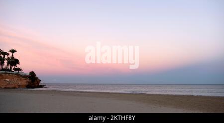 Cielo rosa al tramonto sulla spiaggia in Spagna Foto Stock