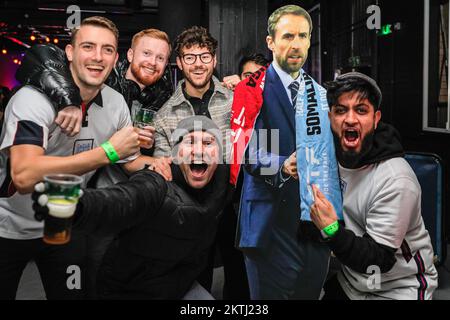 Londra, Regno Unito. 29th Nov 2022. Un gruppo festeggia con un taglio di Gareth Southgate. I fan inglesi festeggiano i tre gol e vincono, mentre i fan del Galles sono delusi, ma si uniscono alla buona atmosfera del locale. Gli appassionati di Inghilterra e Galles guardano la partita di calcio della Coppa del mondo Inghilterra vs Galles al Fan Park 4TheFans, allestito al Dalston Roof Park. L'analisi di batter e match alla proiezione è fornita dalla leggenda del calcio Steve Hodge. Credit: Imageplotter/Alamy Live News Foto Stock