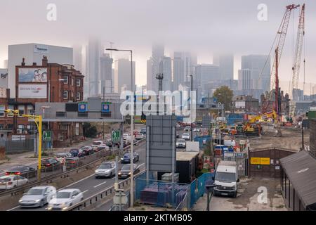 Nebbia, skyline dell'Isola di Dogs in lontananza, punto di vista dalla strada di avvicinamento Sud del Tunnel Blackwall, con traffico intenso, Greenwich, Londra Sud. Foto Stock