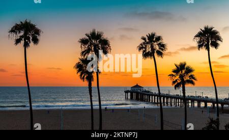Spiaggia al tramonto con palme a Manhattan Beach, California. Viaggi di moda e concetto di spiaggia tropicale. Foto Stock