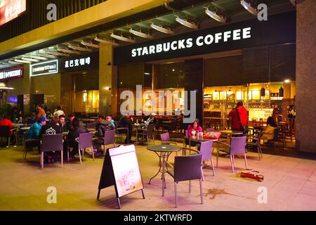 SHENZHEN, CINA - 22 GENNAIO 2015: Starbucks Cafe di notte. Starbucks Corporation è un'azienda americana globale di caffè e una catena di caffè con sede in Foto Stock